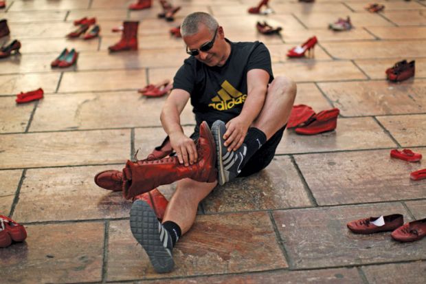 Man compares shoes, La Constitucion Square, Malaga, Spain