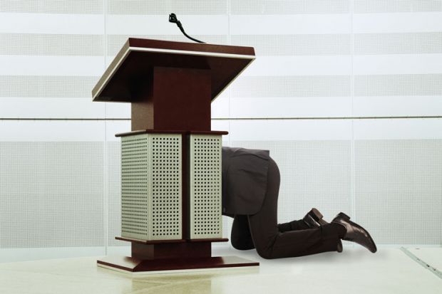 Man hiding behind podium