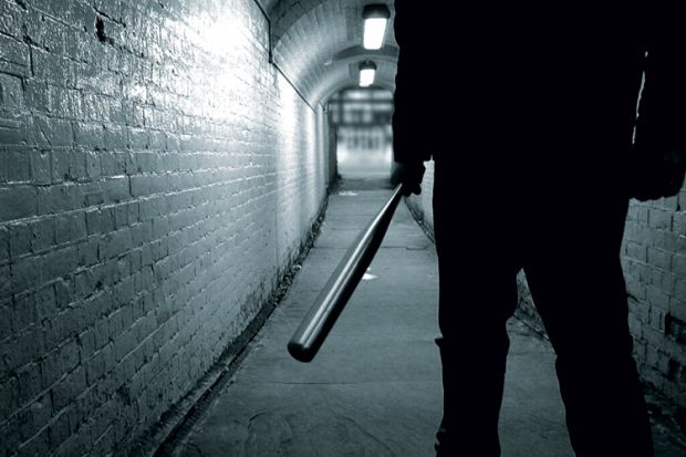 Man holding baseball bat in tunnel