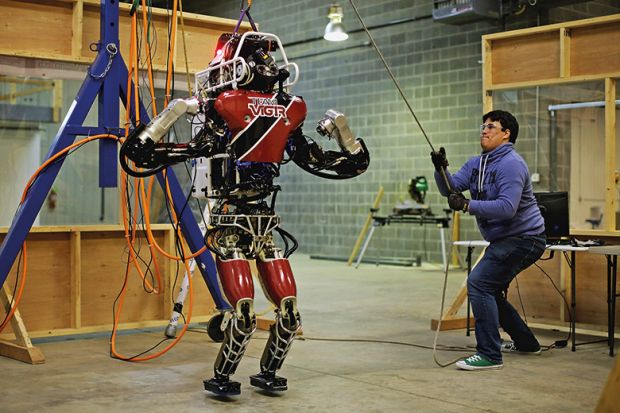 Man lifting robot for testing in preparation for the Defense Advanced Research Projects Agency (DARPA) robotic challenge