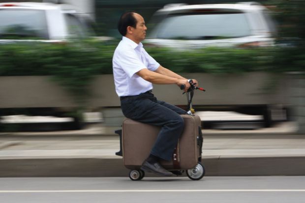 Man rides on electric suitcase