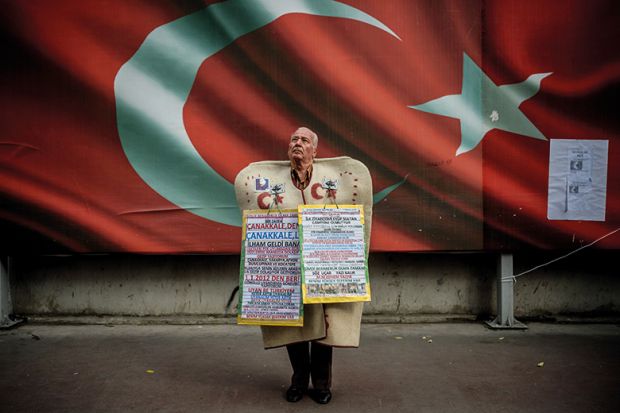 Man standing in front of Turkish national flag