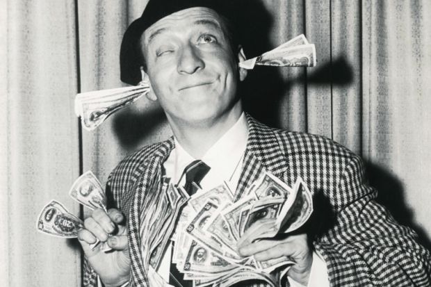 Smiling man with banknotes stuffed in ears and hands