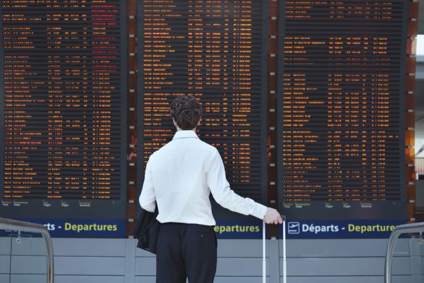 Man looking at airport departure board