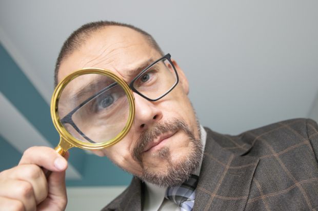 Man looking through a magnifying glass