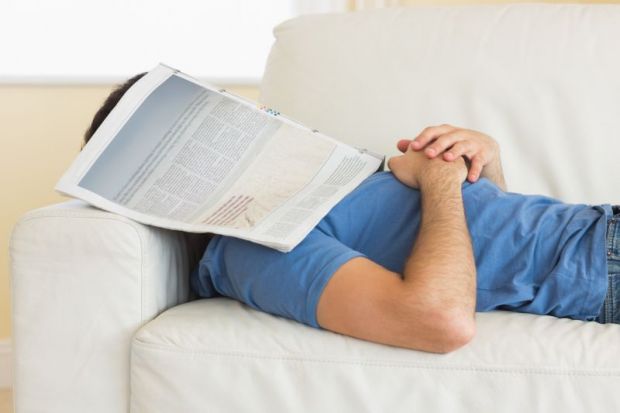 Man sleeping under newspaper