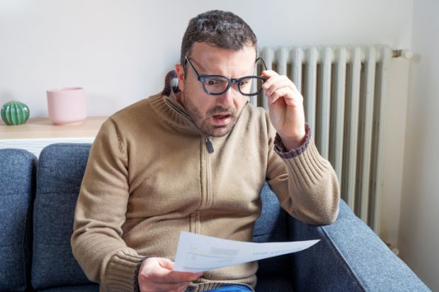 man worried about bills reading energy increase costs
