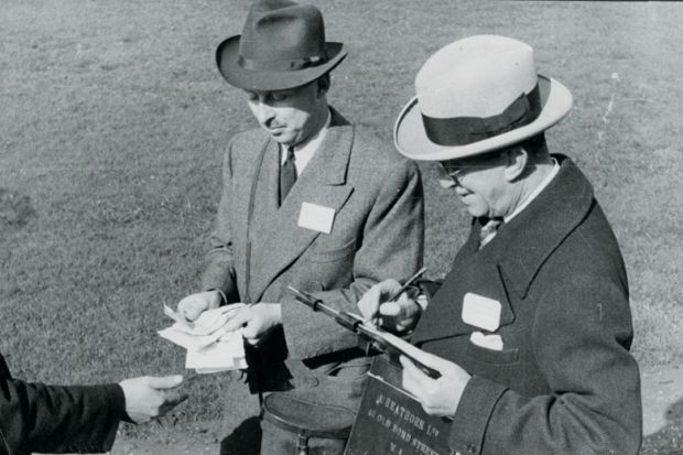 Men paying out winnings at a racecourse