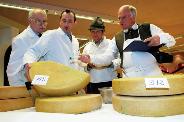 Men inspecting cheeses