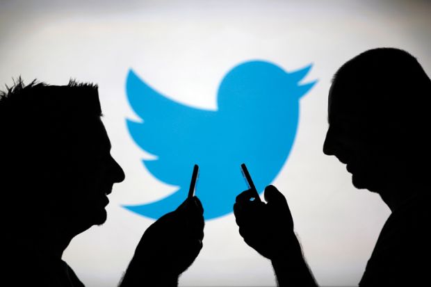 Men using smartphones against Twitter logo backdrop