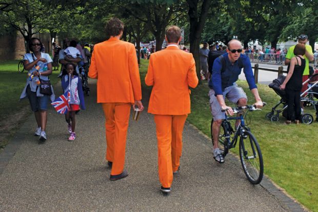 Men walk along wearing matching orange suits