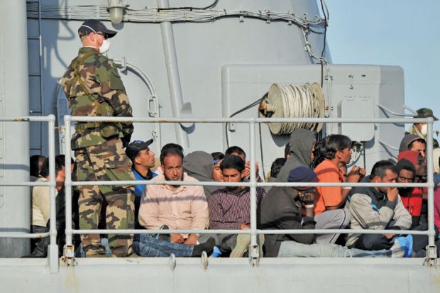 Migrants sitting on a rescue ship