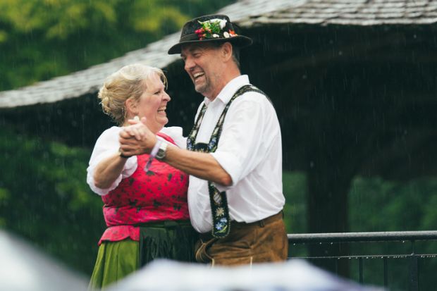 Munich, Germany – June 21, 2019 People in traditional bavarian german tracht called dirndl dancing during the Kocherball event on very rainy wet weather