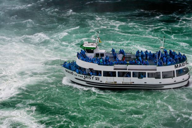 Niagara Falls, NY, USA - June 13, 2019 Ship with tourists moves to Niagara falls, Falls boat tour experience is North America oldest attraction, and has drawn millions of visitors since 1846