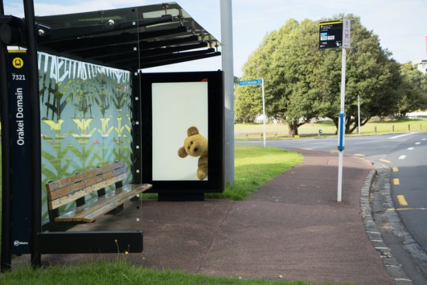 Orakei, Auckland, New Zealand. Pictures of teddy bears in bus shelter electronic billboard for the New Zealand Bear hunt to help keep children entertained during the coronavirus lockdown
