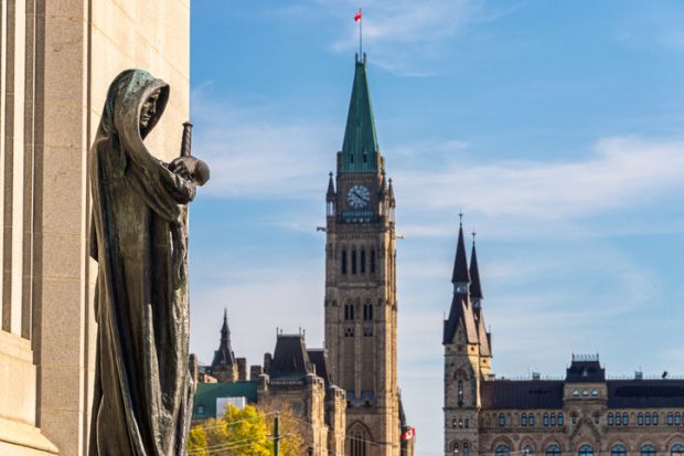 Ottawa, CA - 9 October 2019 Statue Ivstitia (Justice) in front of court Supreme of Canada with Canadian Parliament in background. The statue was made by canadian artist Walter S. Allward circa 1920