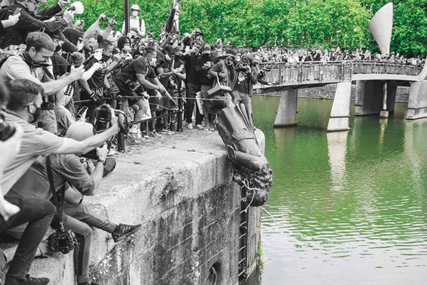 The statue of Edward Colston is pushed into the river Avon