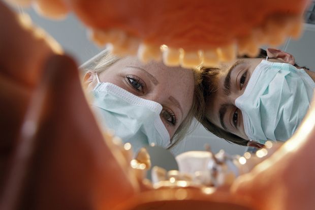 View from within a set of dentures onto two future dentists during their dental training