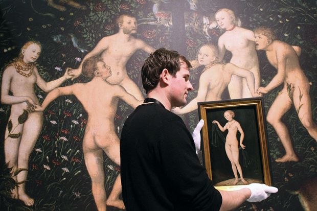 An employee of the Städel Museum gives Venus by Lucas Cranach the Elder the white-glove treatment