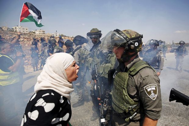 Palestinian woman argues with Israeli border policeman, West Bank
