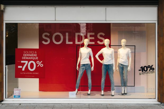 Paris, France - Jul 27, 2017 Soldes inscription with mannequins wearing elegant clothes and special last minutes 70 percent discount sales for fashion products on central Avenue
