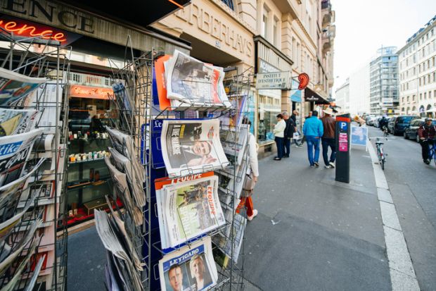 Paris International newspapers at press kiosk wih newspaper and pictures of French Presidential election candidates, Emmanuel Macron, Marine Le Pen a day after first round of French Presidential election on April 23, 2017