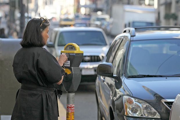 Woman pays a parking meter
