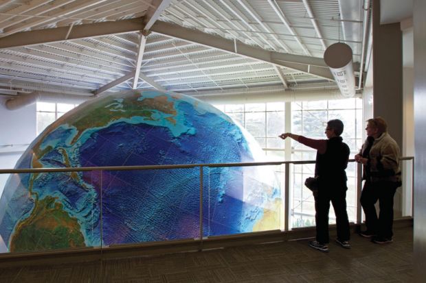 People viewing rotating globe, DeLorme Map Store, Yarmouth, Maine