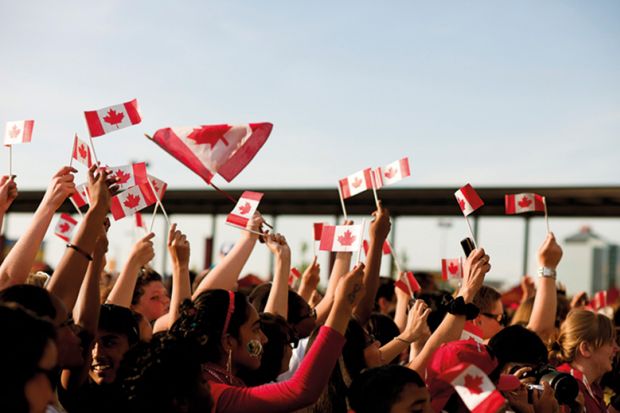 People waving Canadian flags