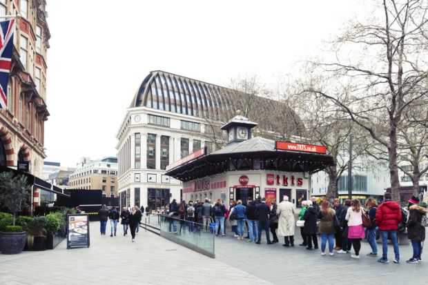People queue for buying tickets from TKTS, the official London theatre ticket booth located at Leicester Square offering last minute and discount tickets for West End shows