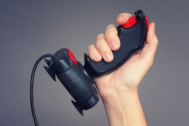 Person holding retro gaming joystick in hand