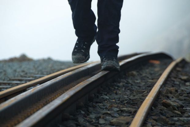 Person walking on rail tracks (detail)