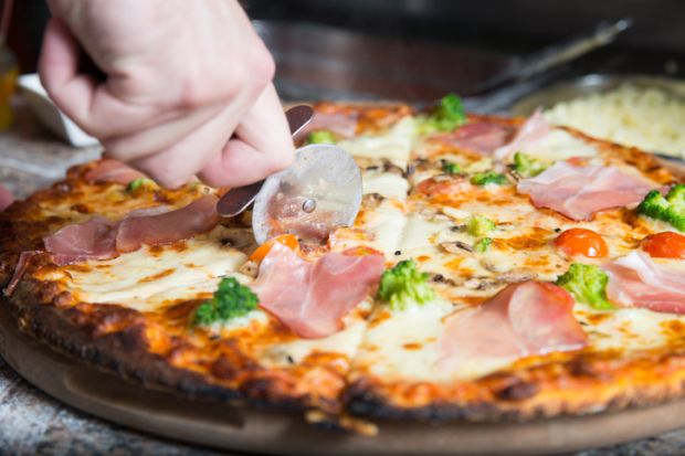 A pizza being sliced