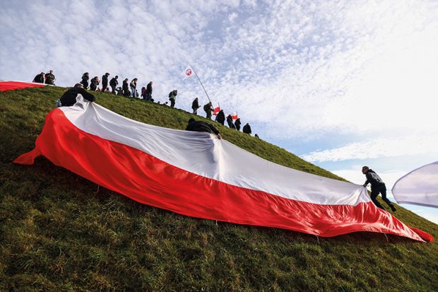 People carry huge Polish flag while attending National Liberation Rally to illustrate Fears for future of top research agency 