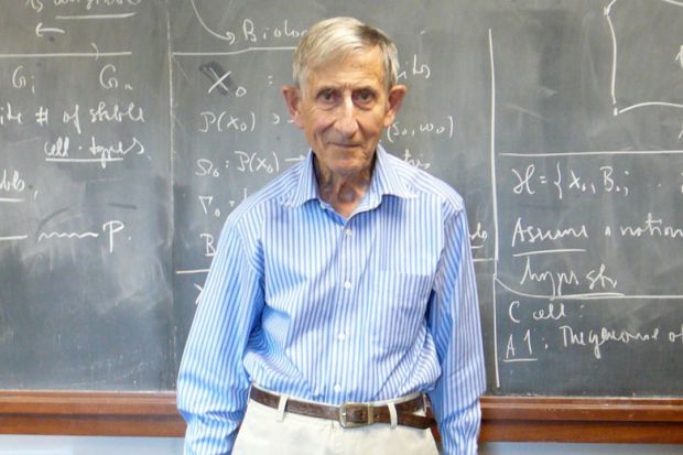 Professor Freeman Dyson standing in front of lecture hall blackboard