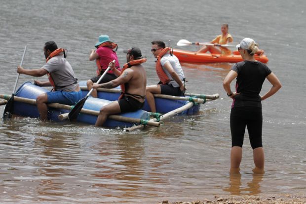 People paddling on a makeshift raft