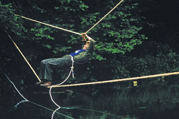 Man crosses river via rope