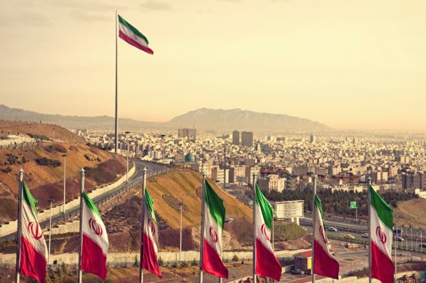 Row of Iran flags against Tehran skyline
