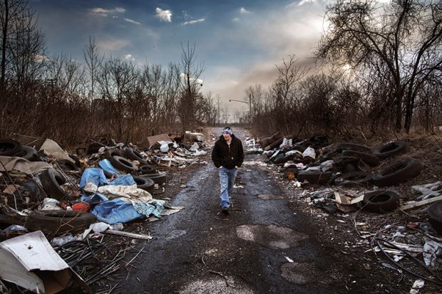 Man walks through a rubbish strewn road