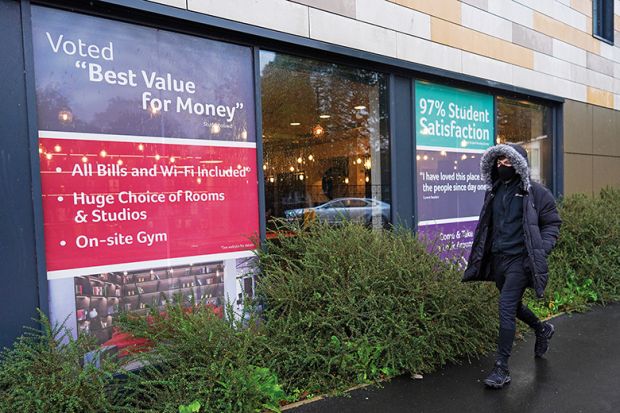 Man walks past office renting student accommodation illustrating education’s value for money