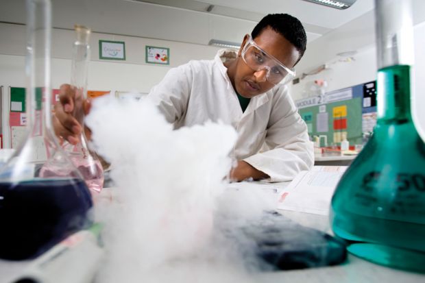 Science pupil performing experiment, Bristol City Academy