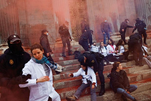 Police officers try to prevent Scientist Rebellion activists from throwing red paint at the exterior of the Spanish Parliament to protest climate change, in Madrid, Spain, April 6, 2022