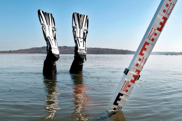 Scuba diver nose-diving into shallow water