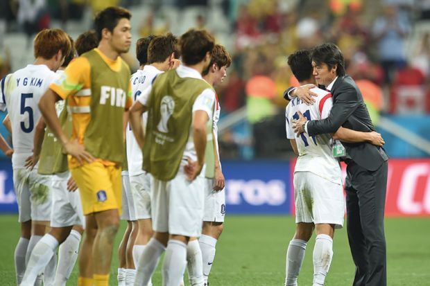 South Koreas football coach hugs one player