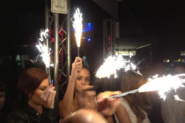 Women holding sparklers at party