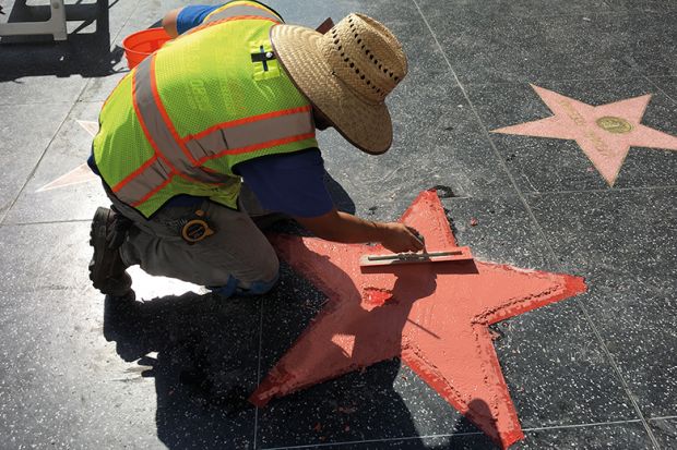 A worker repairs a star on the Hollywood Walk of Fame