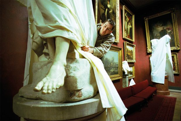 Statue being covered with a dust sheet. To suggest there is less on show for A Level students who are choosing a less diverse range of subjects. 