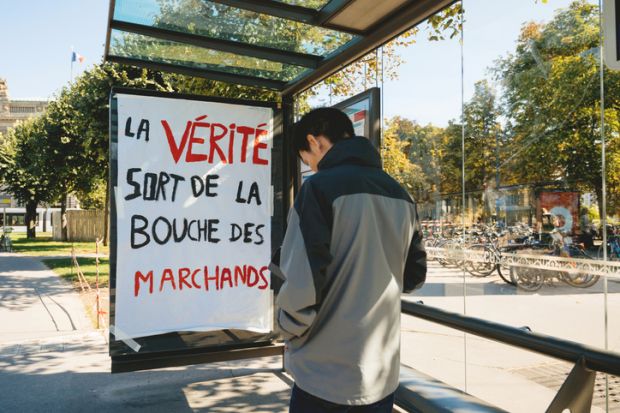 Strasbourg, France - Sep 21, 2019 Man in front of protest placard at bus station during the largest worldwide climate march change started by Swedish climate activist Greta Thunberg