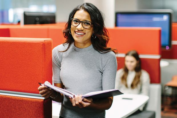 Student with book in Leeds University library