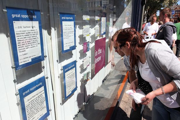 Students look at job vacancies on display in the window to illustrate ‘Radical rethink’ needed as work vies with study